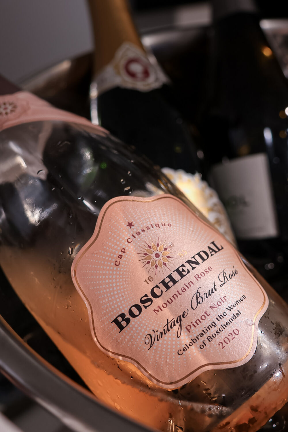 Rosé-Schaumwein mit rosa Etikett und Wassertropfen