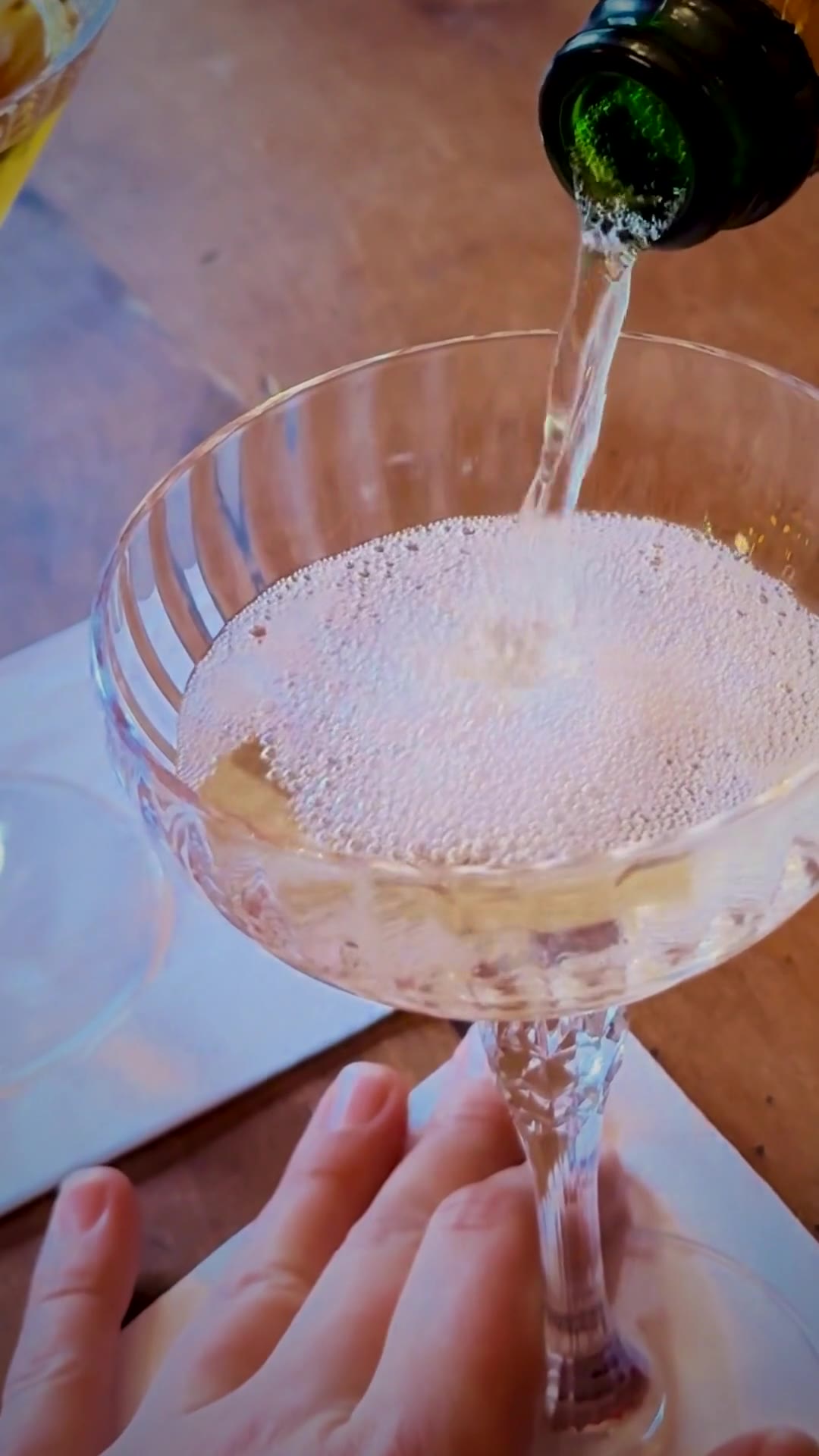 Champagner wird in eine Kristall-Coupe geschenkt